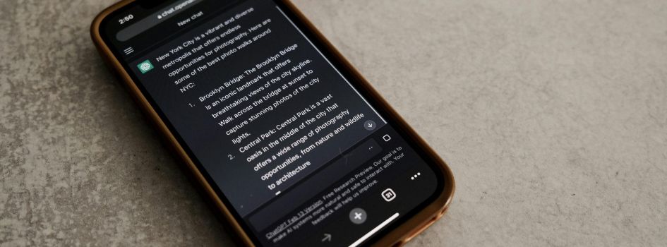 Smartphone σε σκοτεινό περιβάλλον που προβάλλει τη συνομιλία και τις απαντήσεις στην εφαρμογή του ChatGPT.